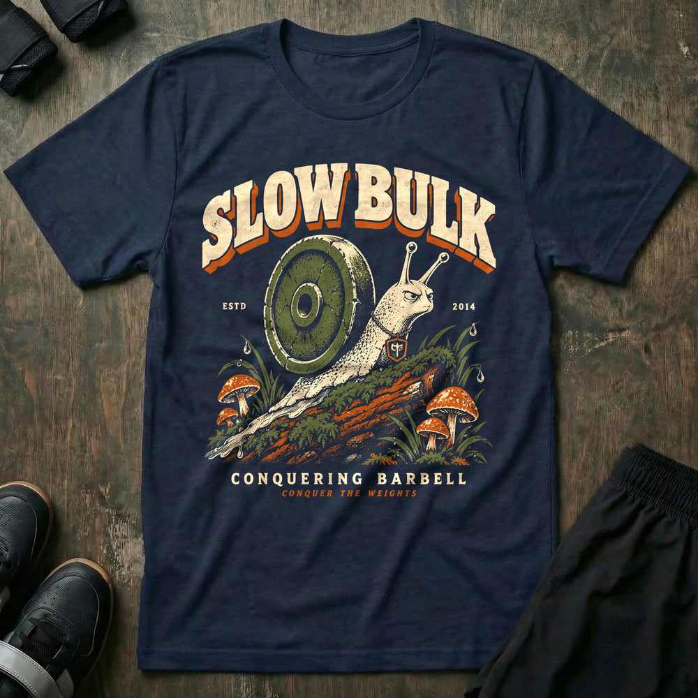 Slow Bulk - Tee front graphic in Navy with a snail with a weight plate for a shell crossing a mossy log - Conquering Barbell