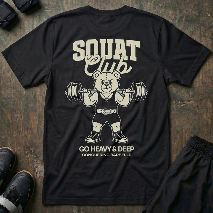 Squat Club tee in Black: a classic teddy bear squatting heavy in a lifting belt with a loaded barbell across his back
