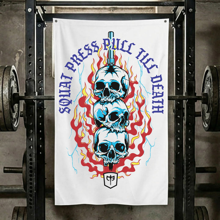 Squat Press Pull® Till Death-White - Polyester Flag, vertical white gym flag with three blue skulls stacked on a sword in red flames - Conquering Barbell