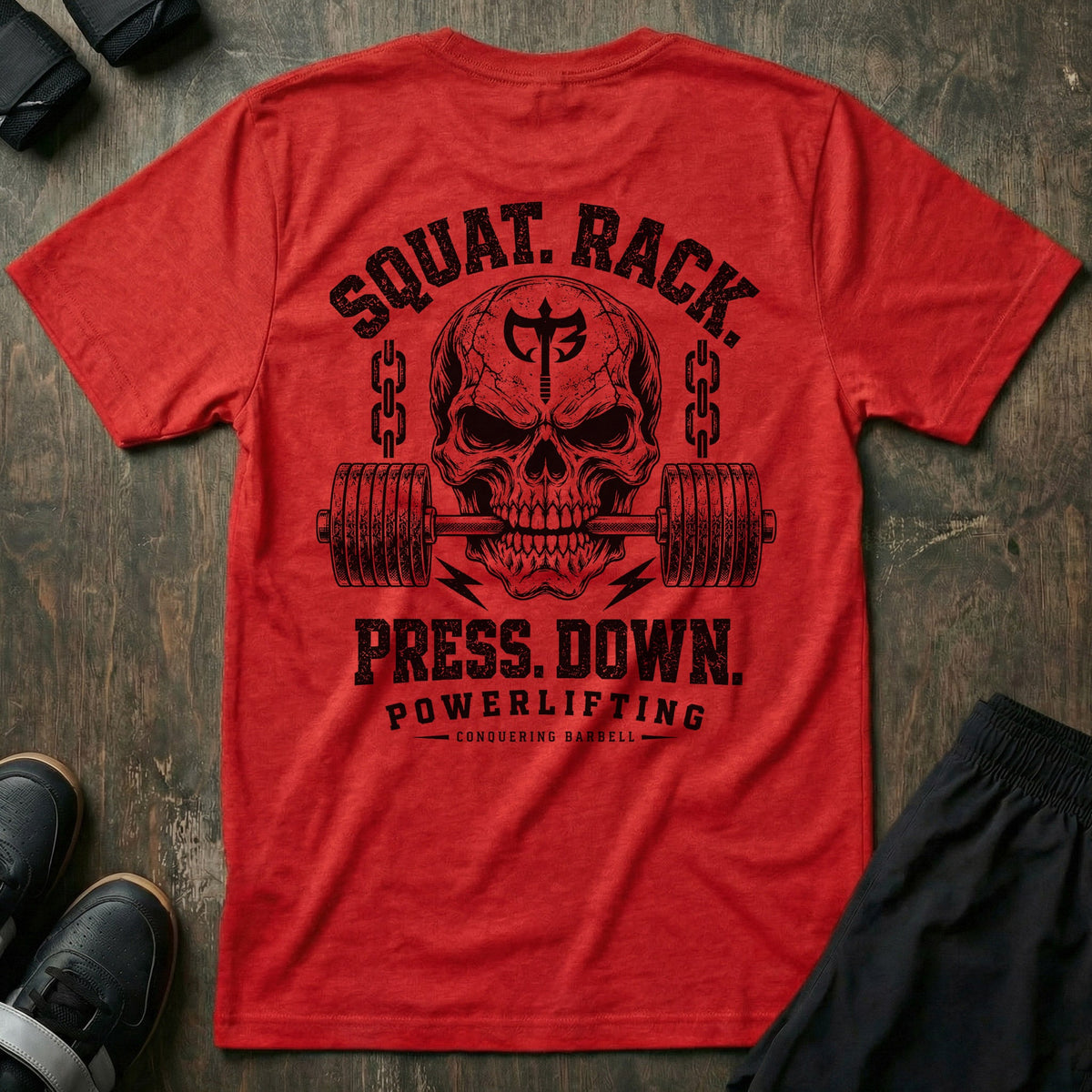 Squat. Rack. Press. Down. tee in Red: a skull with the CB shield biting down on a barbell between chains