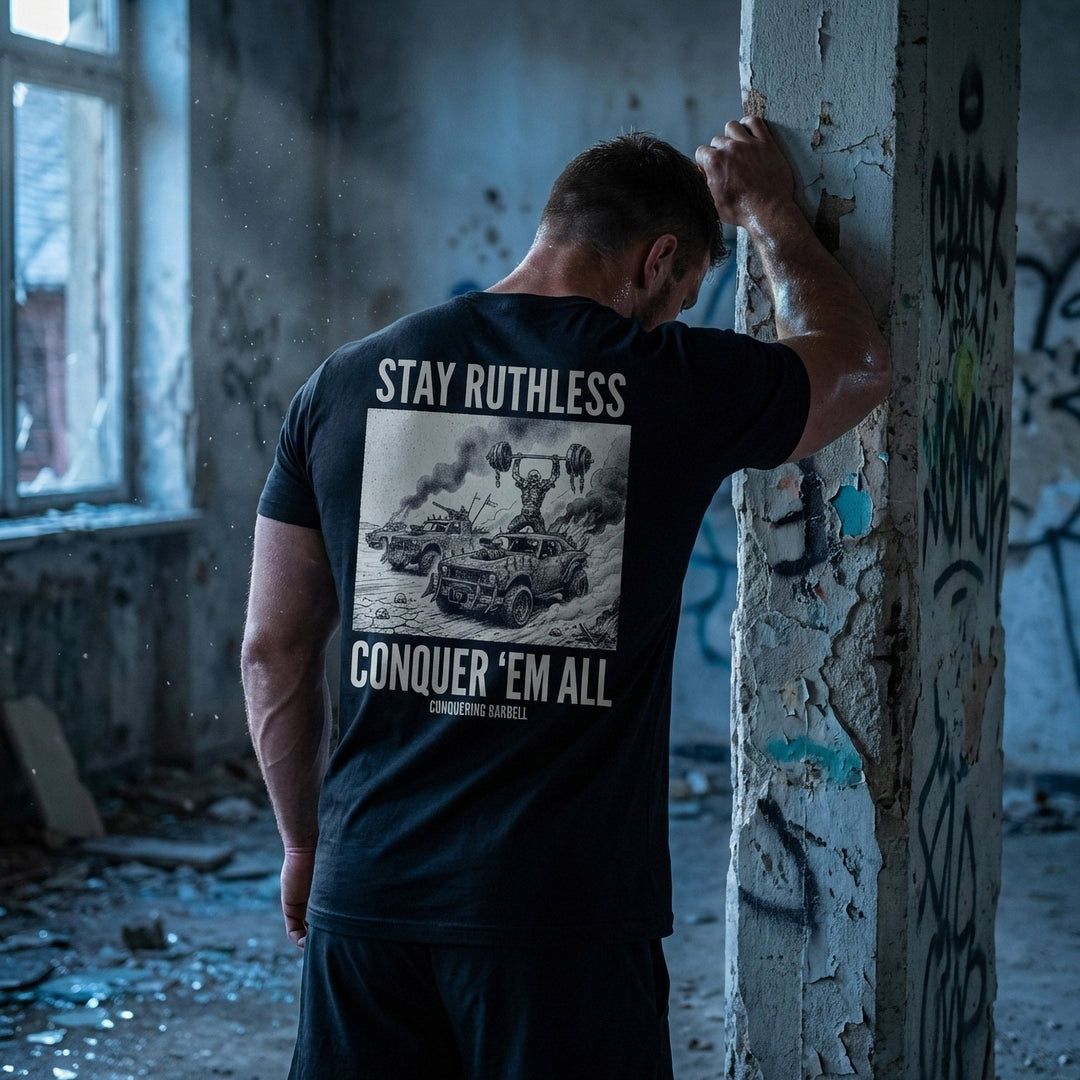Stay Ruthless tee in Black: a skeleton warrior pressing a massive barbell overhead atop a war rig