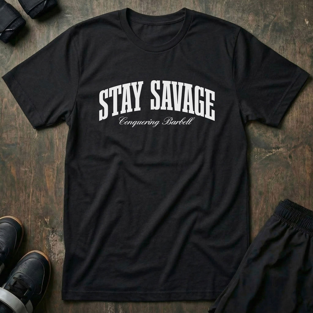 Stay Savage tee in Black: STAY SAVAGE in bold arched collegiate letters with Conquering Barbell script below