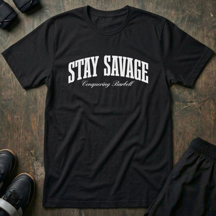 Stay Savage tee in Black: STAY SAVAGE in bold arched collegiate letters with Conquering Barbell script below