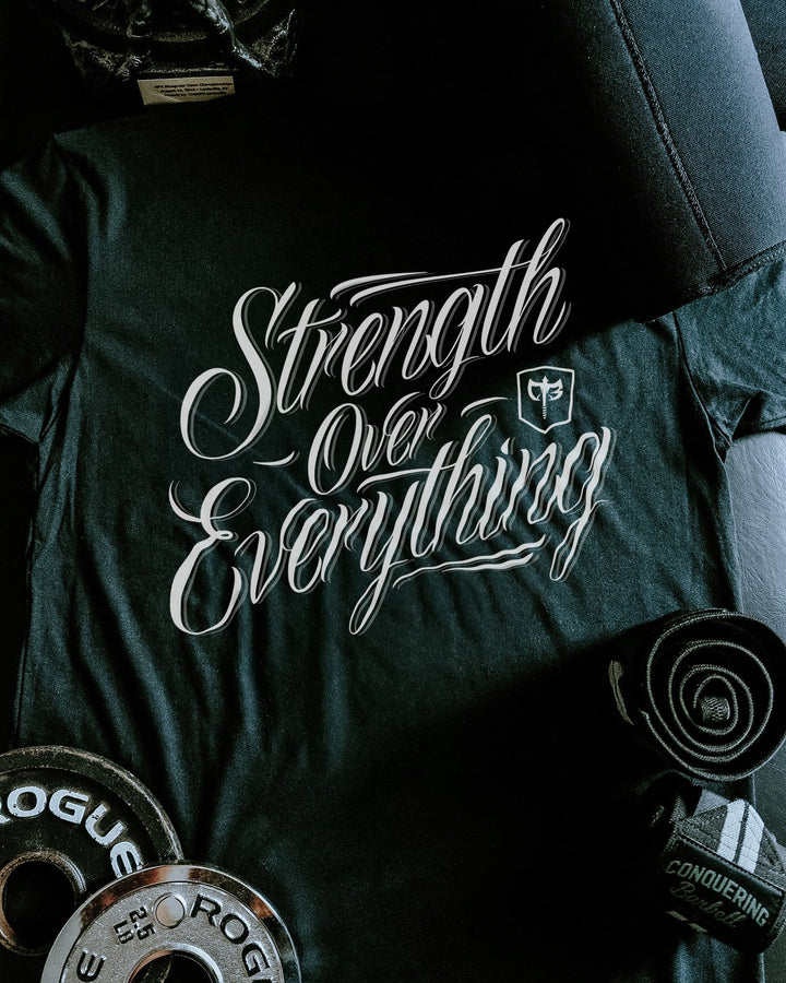 Strength Over Everything tee in Black: Strength Over Everything in sweeping white script with the CB shield across the back