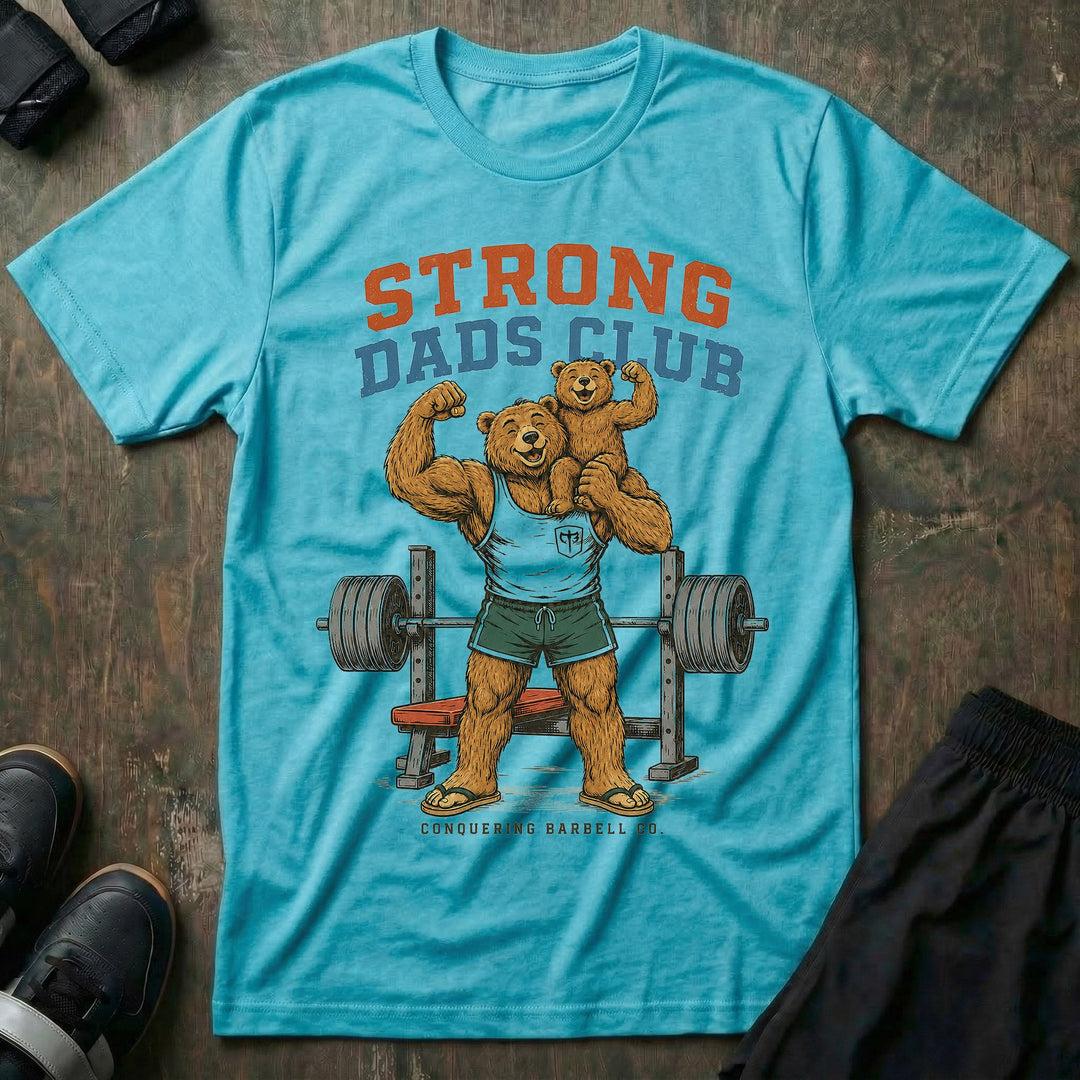 Strong Dads Club tee in Tahiti: a jacked papa bear in a CB tank top and flip flops grinning