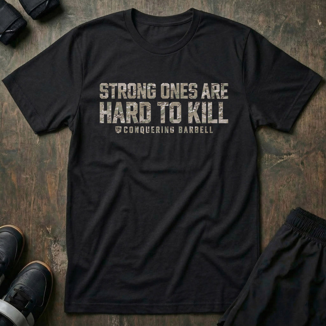 Strong Ones are Hard to Kill tee in Black: STRONG ONES ARE HARD TO KILL in heavy block letters filled with multi-terrain camo
