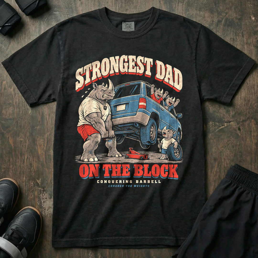 Strongest Dad on the Block - Relaxed Fit Tee front graphic in Black with a rhino dad lifting the back of an SUV by the bumper while a young rhino changes the tire - Conquering Barbell