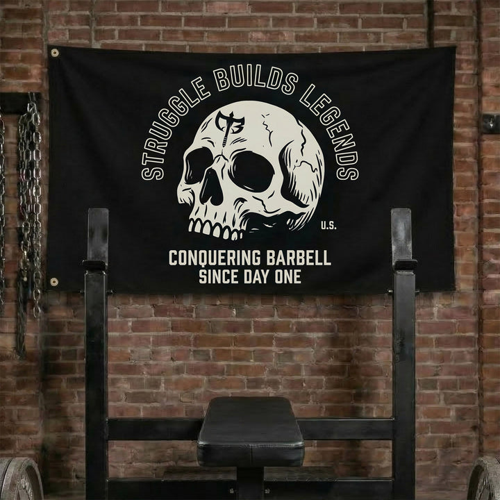 Struggle Builds Legends - Polyester Flag, horizontal black gym flag with cracked skull under arched white lettering - Conquering Barbell