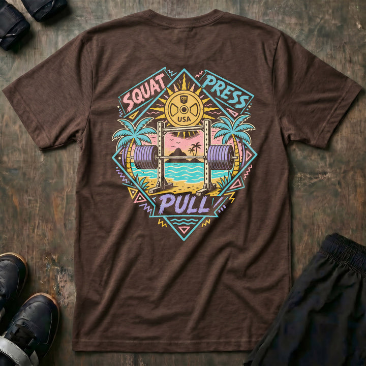 Sunset Iron tee in Expresso: a loaded barbell rack on the sand with palm trees swaying under a pink sun