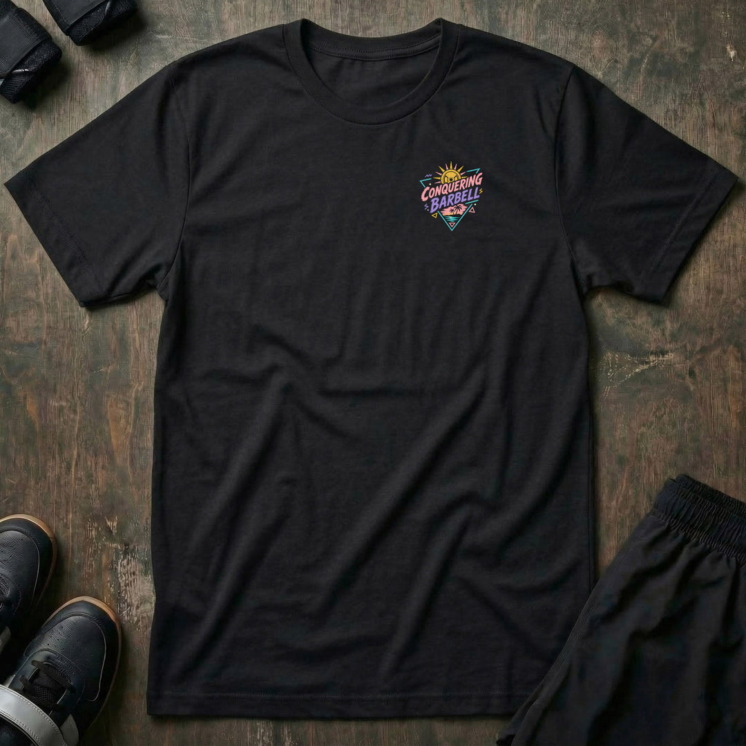 Sunset Iron tee: a loaded barbell rack on the sand with palm trees swaying under a pink sun