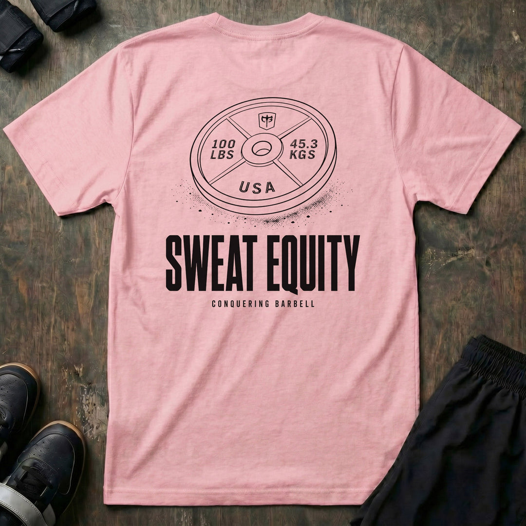 Sweat Equity tee in Pink: a 100 lb USA plate with the CB shield and chalk dust scattered at its base