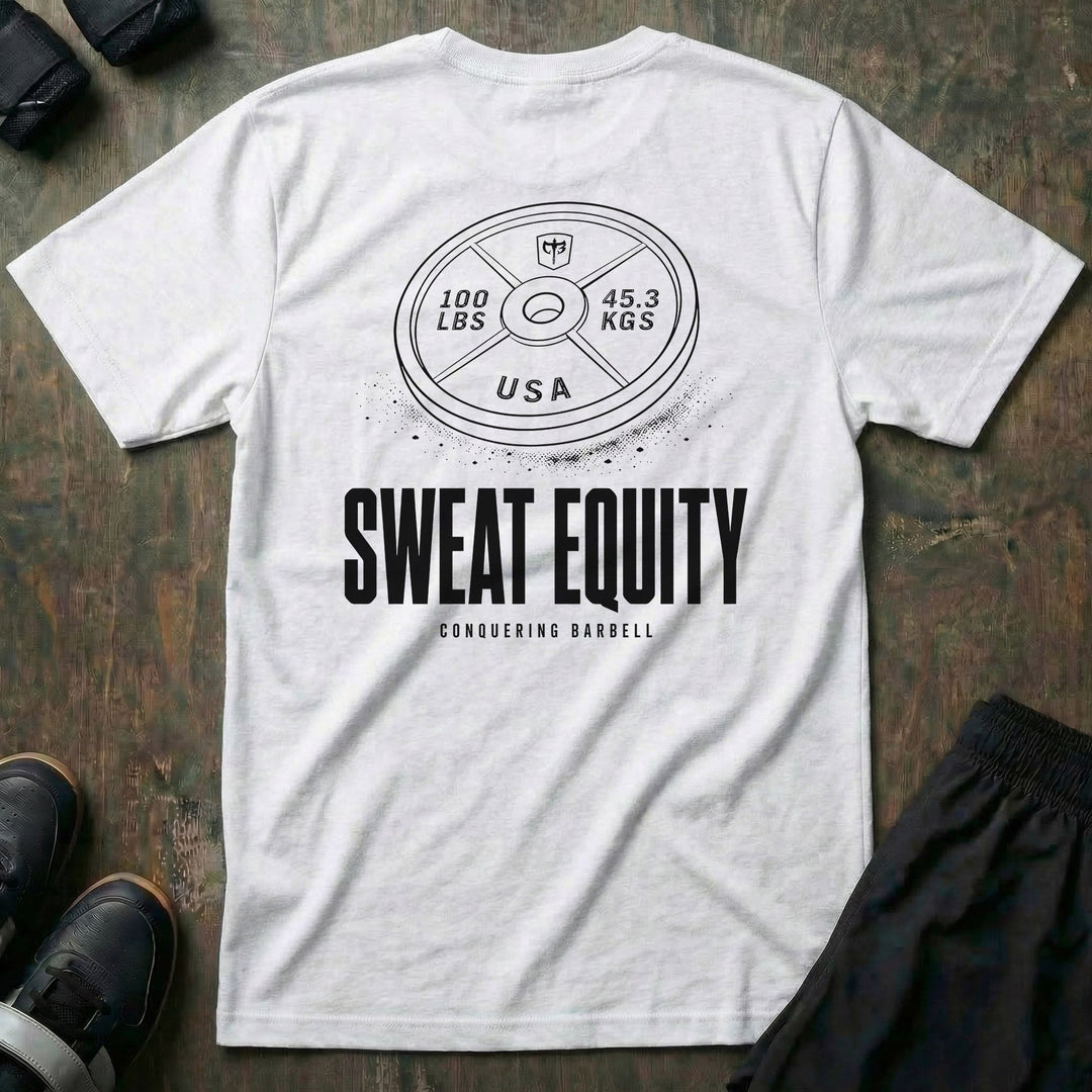 Sweat Equity tee in White: a 100 lb USA plate with the CB shield and chalk dust scattered at its base