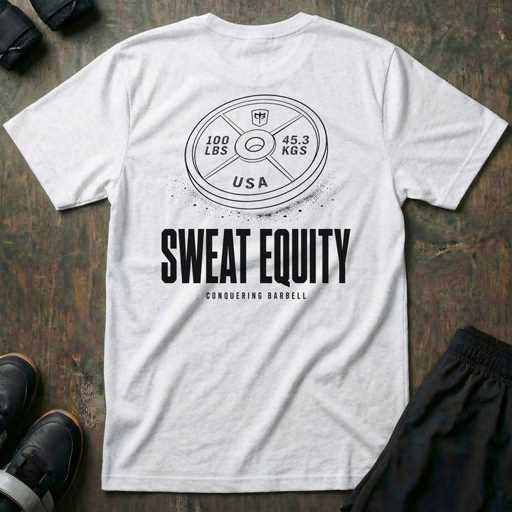 Sweat Equity tee in White: a 100 lb USA plate with the CB shield and chalk dust scattered at its base