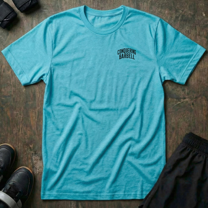 Tandem Deads tee: two athletic women deadlifting side by side on a palm-lined beach at sunset