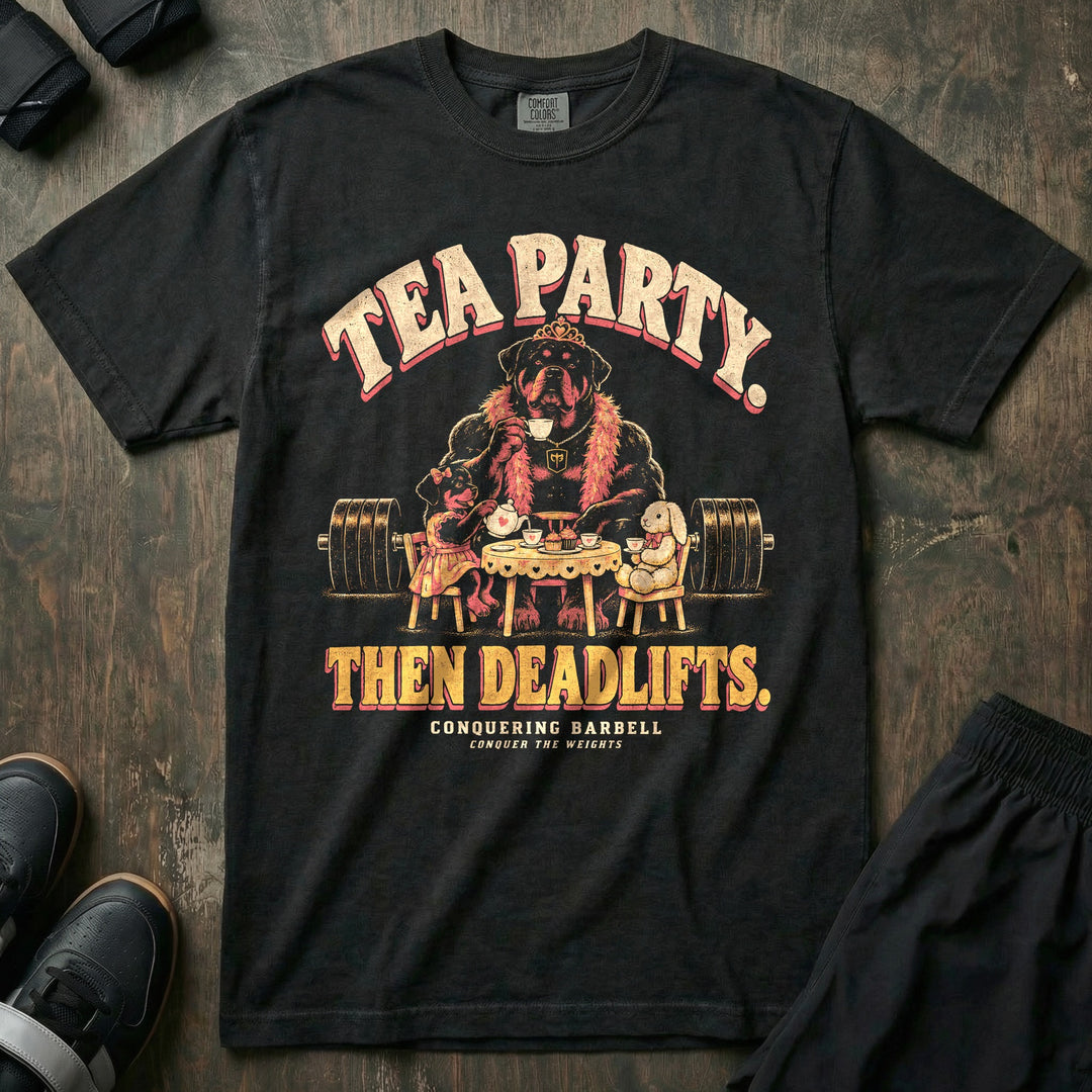 Tea Party. Then Deadlifts - Relaxed Fit Tee front graphic in Black with a rottweiler dad wearing a tiara and pink feather boa drinking tea with his daughter and a stuffed bunny in front of a loaded barbell - Conquering Barbell