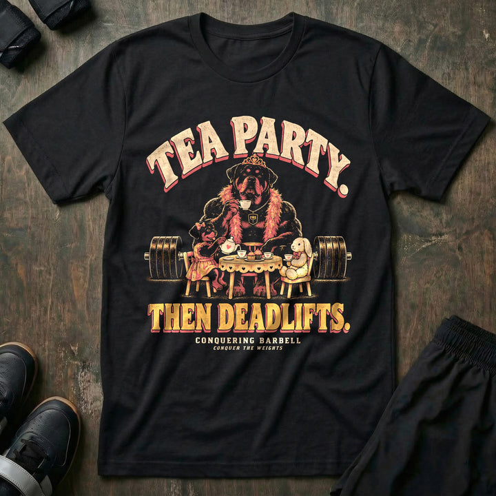 Tea Party. Then Deadlifts - Tee front graphic in Black with a rottweiler dad wearing a tiara and pink feather boa drinking tea with his daughter and a stuffed bunny in front of a loaded barbell - Conquering Barbell