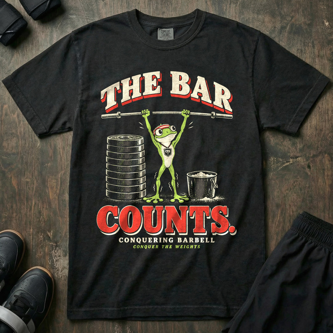 The Bar Counts - Relaxed Fit Tee front graphic in Black with a tiny tree frog in a headband pressing an empty barbell overhead beside a stack of plates - Conquering Barbell
