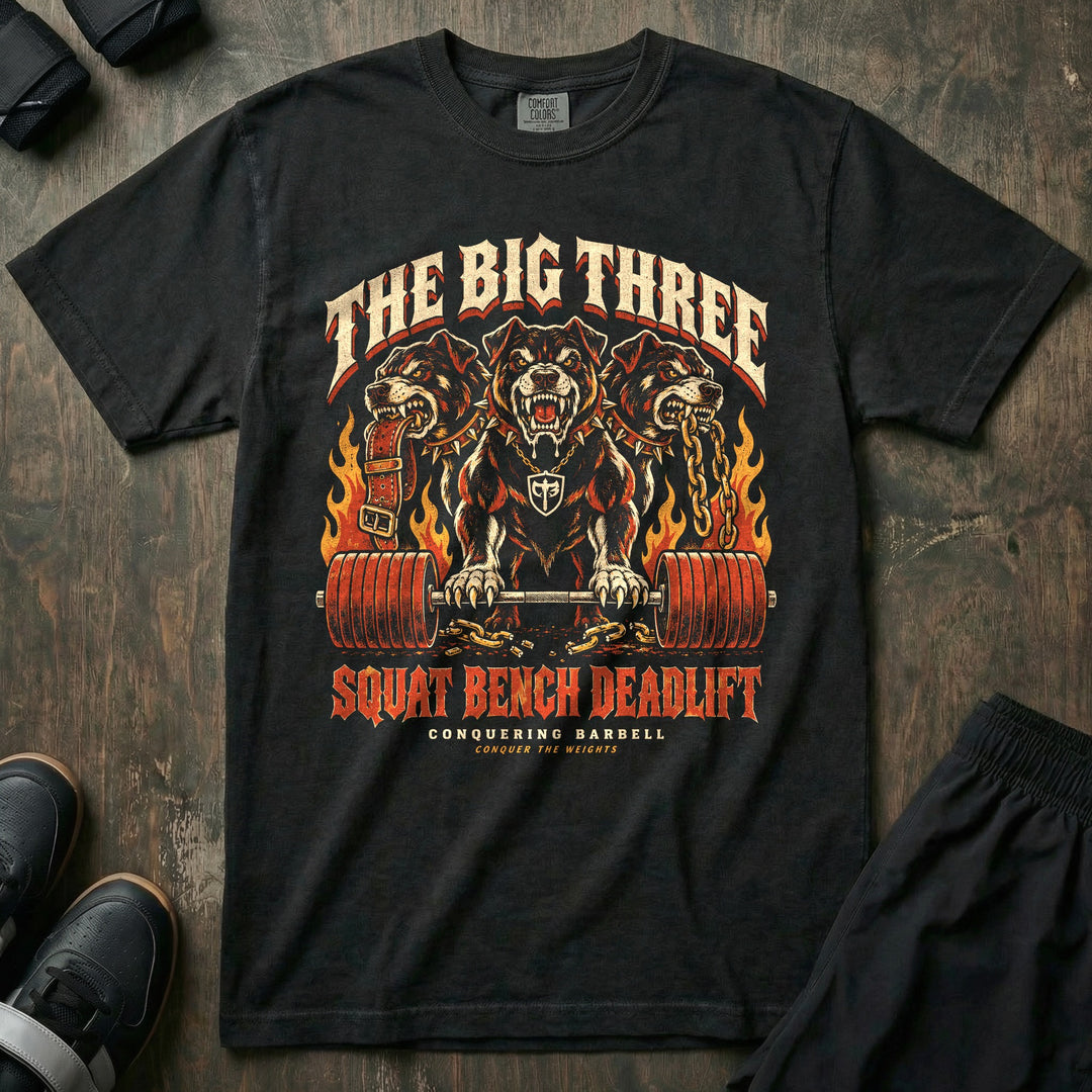 The Big Three - Relaxed Fit Tee front graphic in Black with a three-headed hellhound with a loaded barbell surrounded by flames - Conquering Barbell