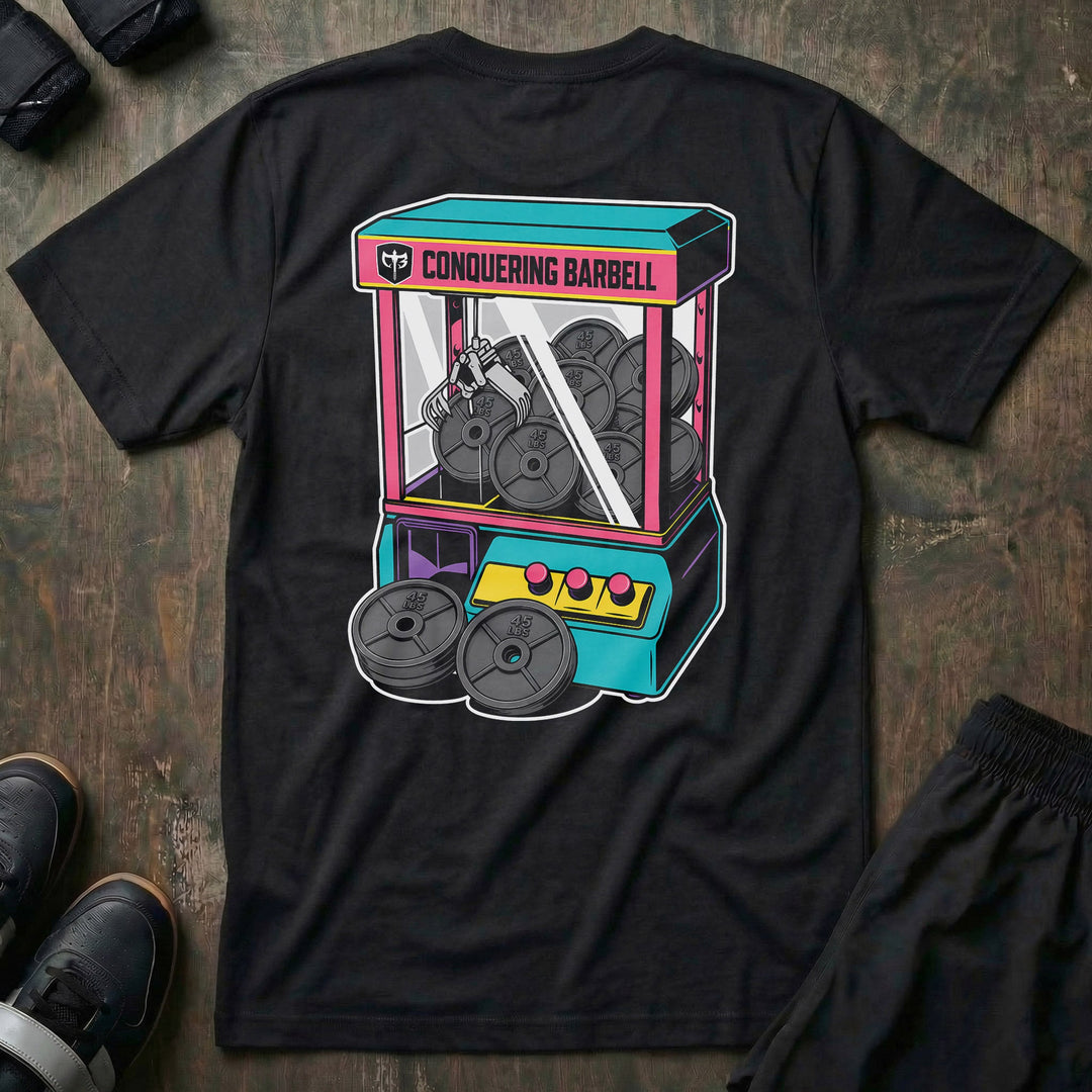 The Claw tee in Black: a retro arcade claw machine packed with 45 lb plates