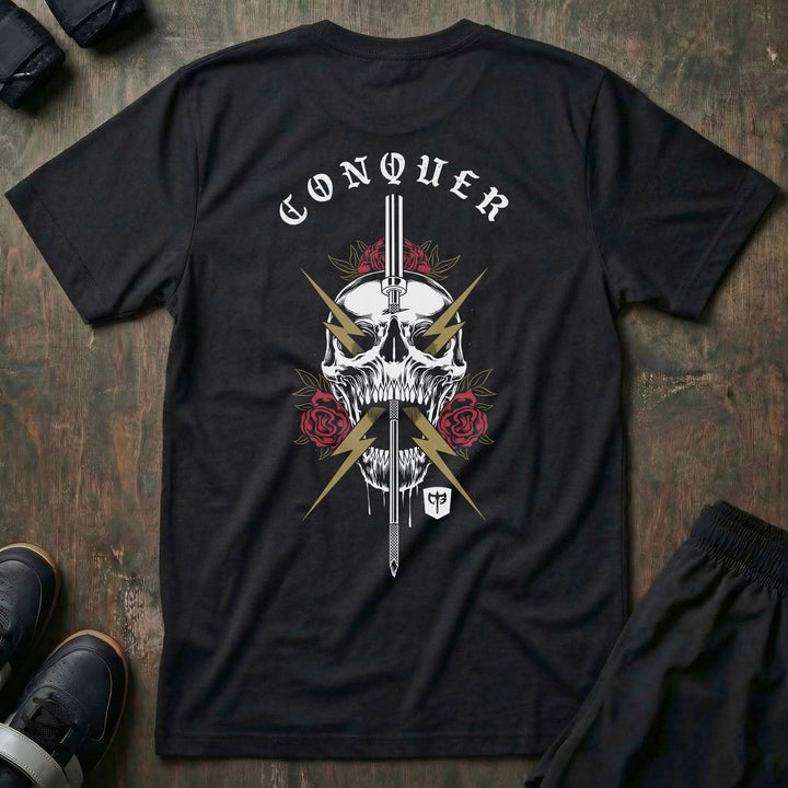 The Conqueror tee in Black: a skull crowned in red roses and run through by a sword crackling with gold lightning