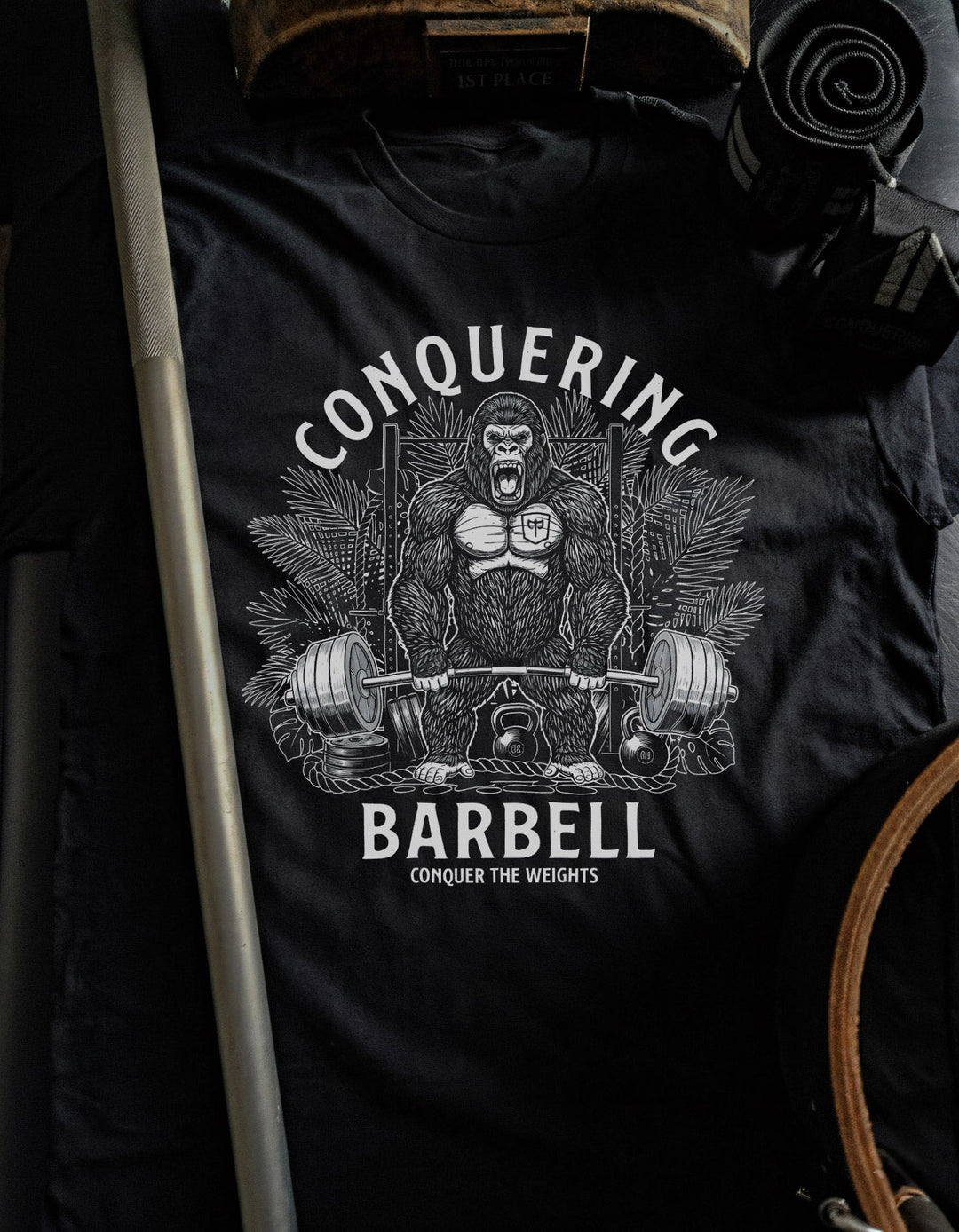 The Silverback tee in Black: a jacked gorilla ripping a heavy barbell in front of a jungle rack