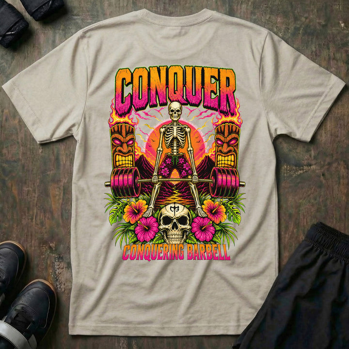 Tiki Power tee in Sand: a skeleton deadlifting a loaded barbell between two flaming tiki torches against a tropical sunset