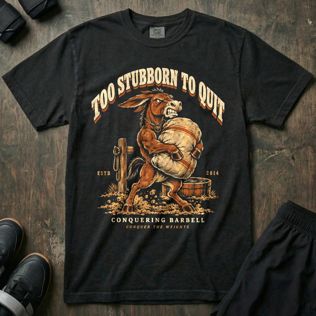 Too Stubborn to Quit - Relaxed Fit Tee front graphic in Black with a mule with teeth bared carrying a heavy sandbag - Conquering Barbell