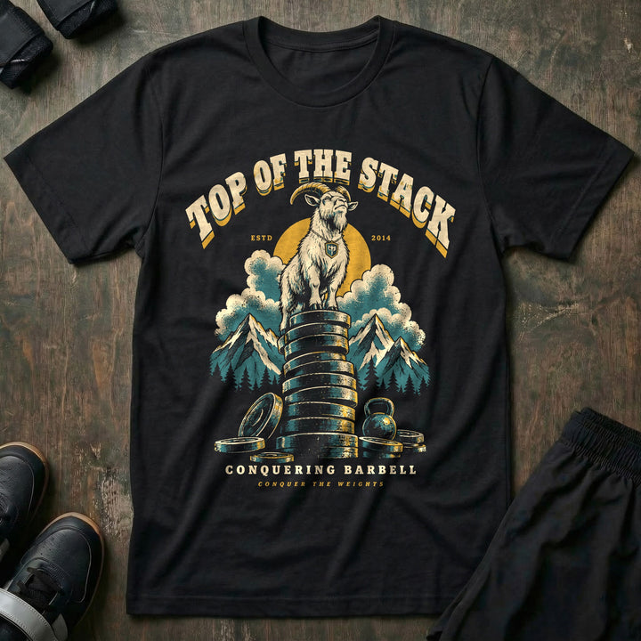 Top of the Stack - Tee front graphic in Black with a mountain goat standing on a tall stack of weight plates above the clouds - Conquering Barbell