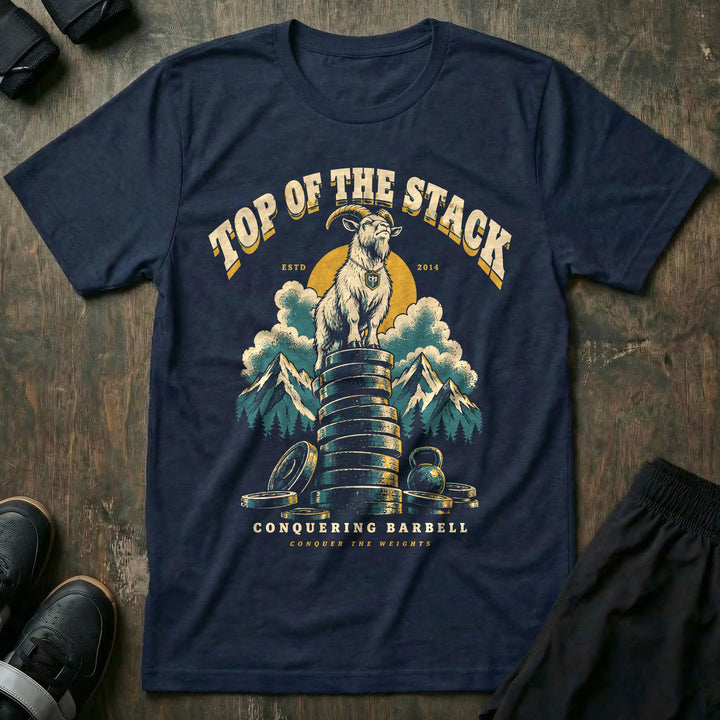 Top of the Stack - Tee front graphic in Navy with a mountain goat standing on a tall stack of weight plates above the clouds - Conquering Barbell