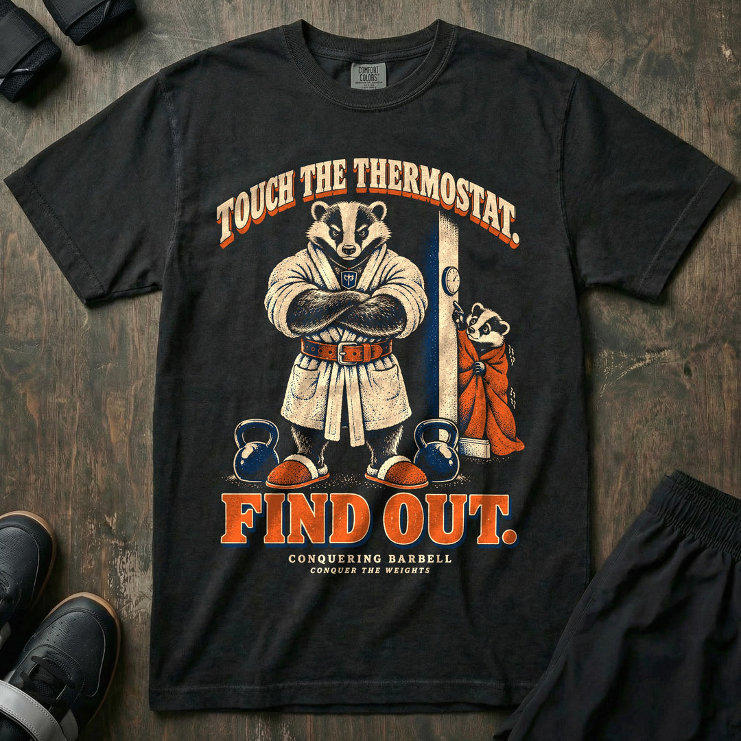 Touch the Thermostat. Find Out - Relaxed Fit Tee front graphic in Black with a badger dad in a bathrobe and lifting belt guarding a thermostat while a shivering young badger reaches for it - Conquering Barbell