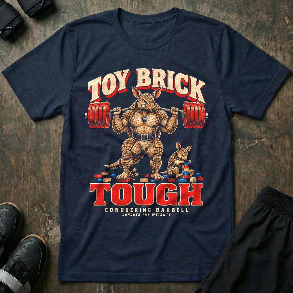 Toy Brick Tough - Tee front graphic in Navy with an armadillo dad with a loaded barbell on his back stepping on a toy brick while a young armadillo stacks building blocks - Conquering Barbell