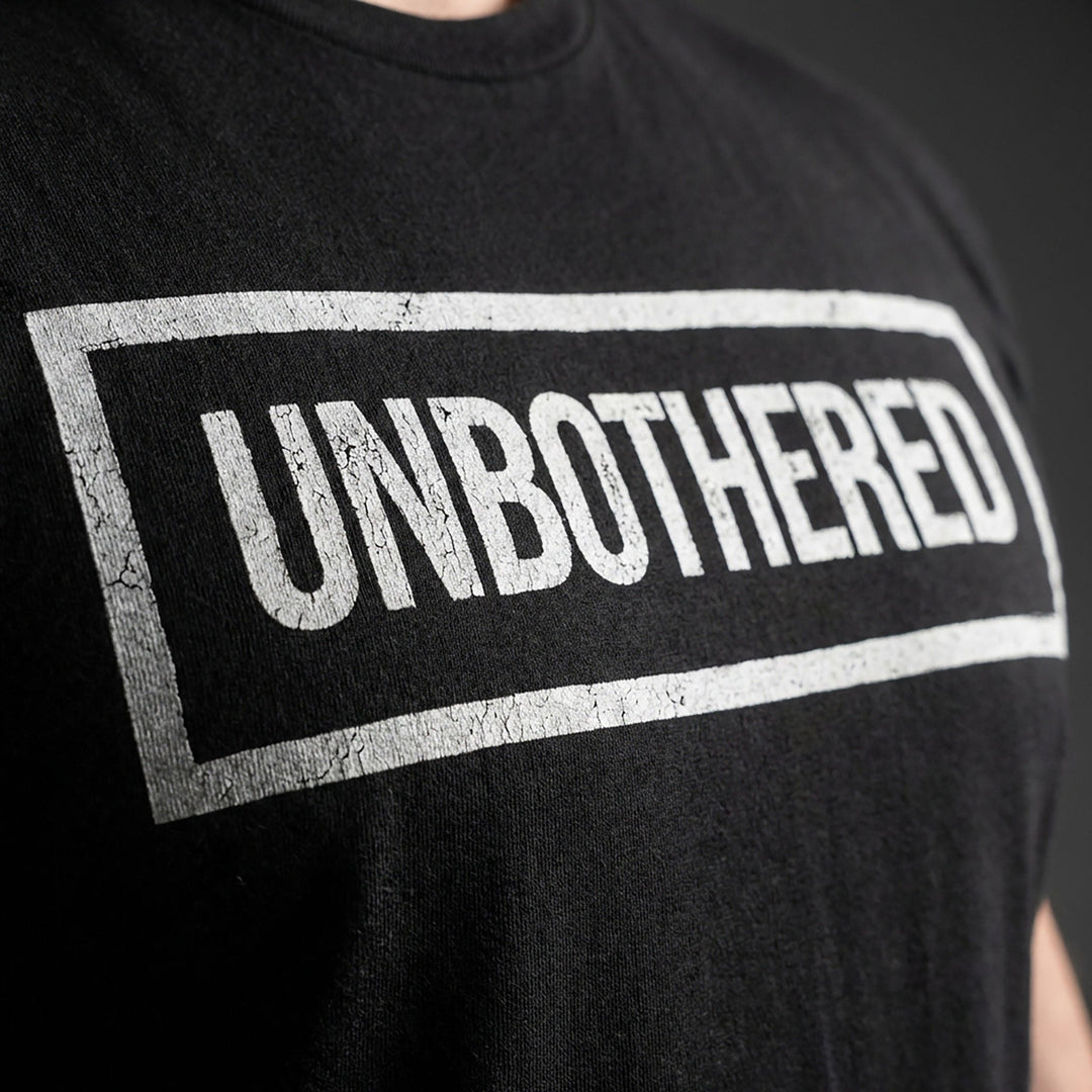 Unbothered tee in Black: UNBOTHERED in distressed block letters inside a bold rectangular frame