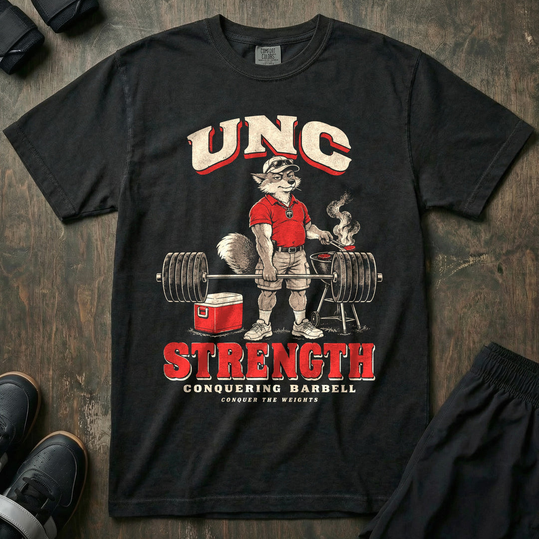 Unc Strength - Relaxed Fit Tee front graphic in Black with a silver fox in a polo holding a loaded barbell one-handed while flipping burgers on a grill - Conquering Barbell