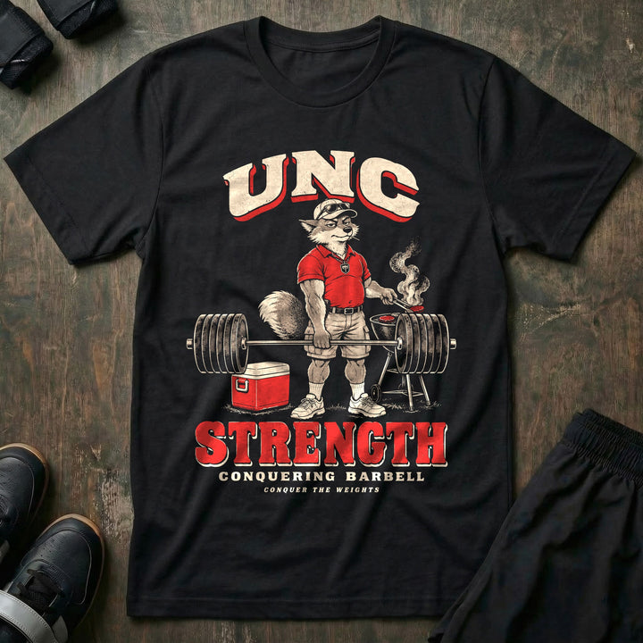 Unc Strength - Tee front graphic in Black with a silver fox in a polo holding a loaded barbell one-handed while flipping burgers on a grill - Conquering Barbell