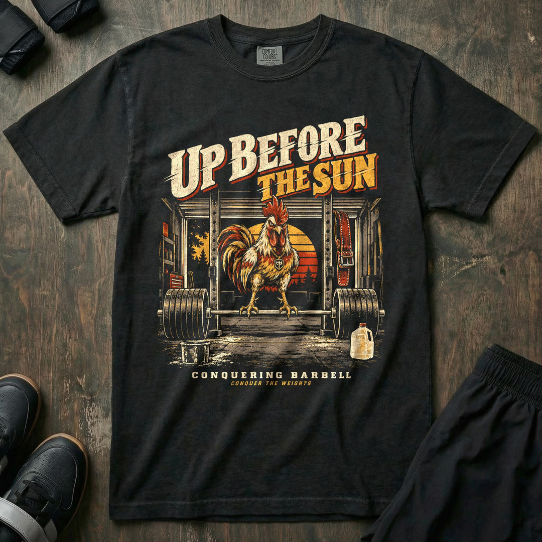 Up Before the Sun - Relaxed Fit Tee front graphic in Black with a rooster perched on a loaded barbell in a garage gym at sunrise - Conquering Barbell