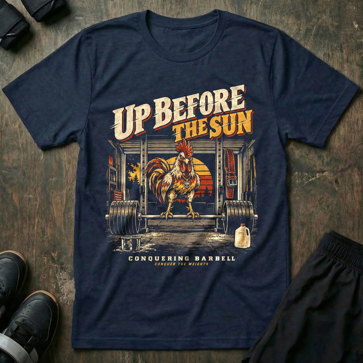 Up Before the Sun - Tee front graphic in Navy with a rooster perched on a loaded barbell in a garage gym at sunrise - Conquering Barbell