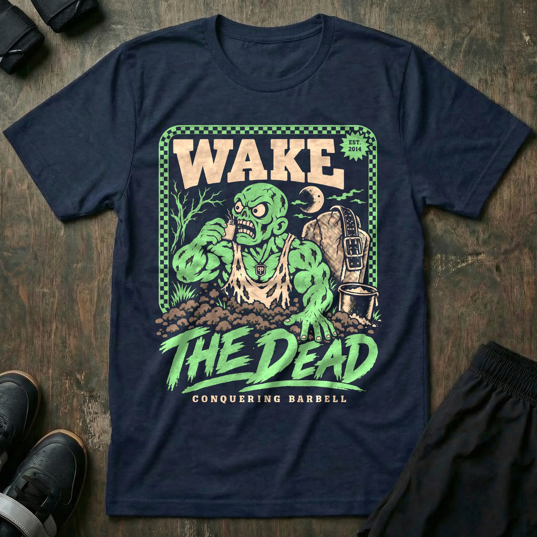 Wake the Dead V2 - Tee front graphic in Navy with a zombie lifter climbing out of a grave sniffing smelling salts beside a tombstone with a lifting belt hung on it - Conquering Barbell