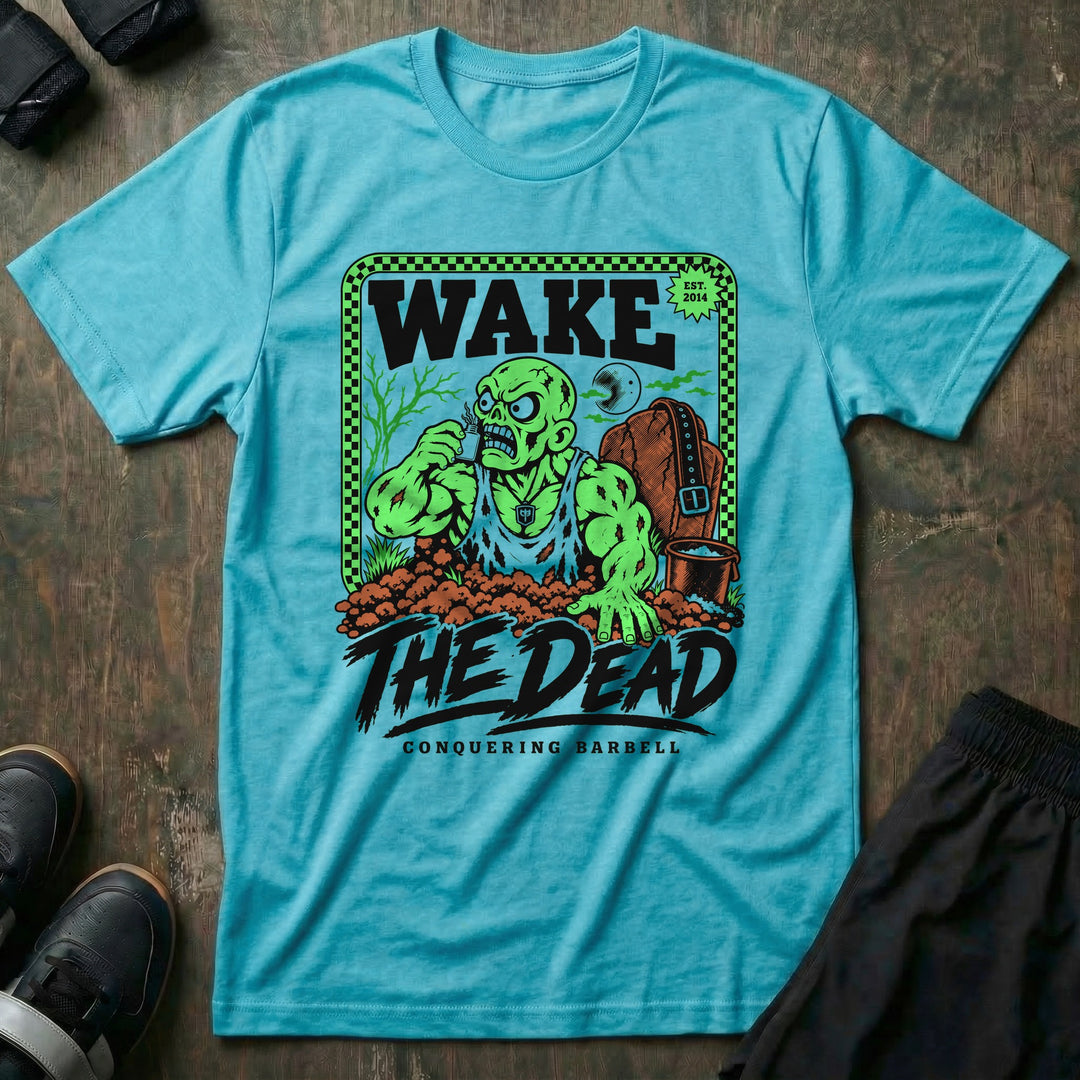Wake the Dead V2 - Tee front graphic in Tahiti with a zombie lifter climbing out of a grave sniffing smelling salts beside a tombstone with a lifting belt hung on it - Conquering Barbell