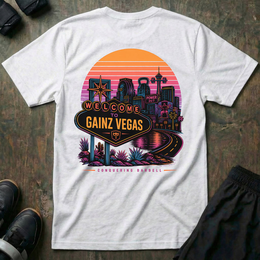 Welcome to Gainz Vegas tee in White: a neon-soaked city skyline at sunset with a WELCOME TO GAINZ VEGAS marquee sign