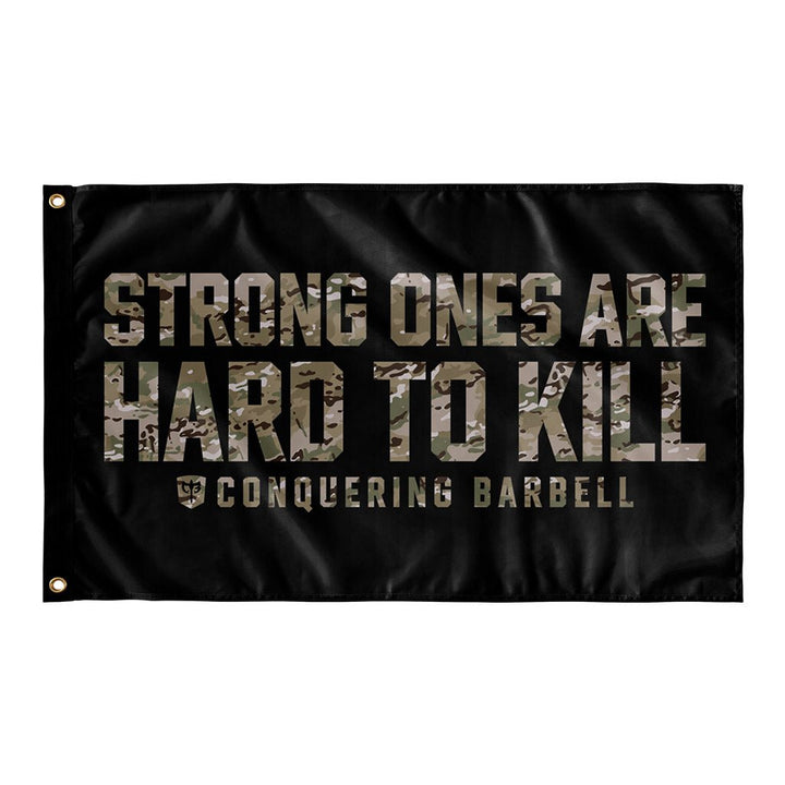 Strong Ones are Hard to Kill - Multi Camo - Polyester Flag, horizontal gym flag hanging in a home gym - Conquering Barbell